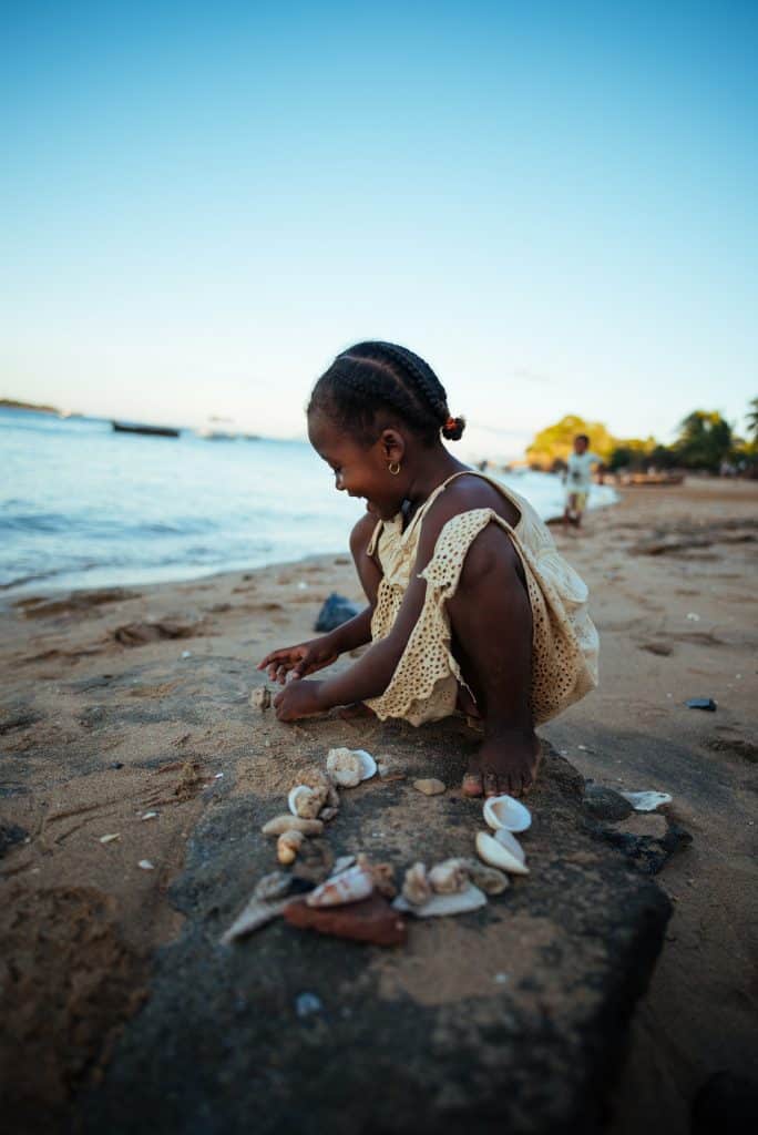 girl on the shore collecting seashells