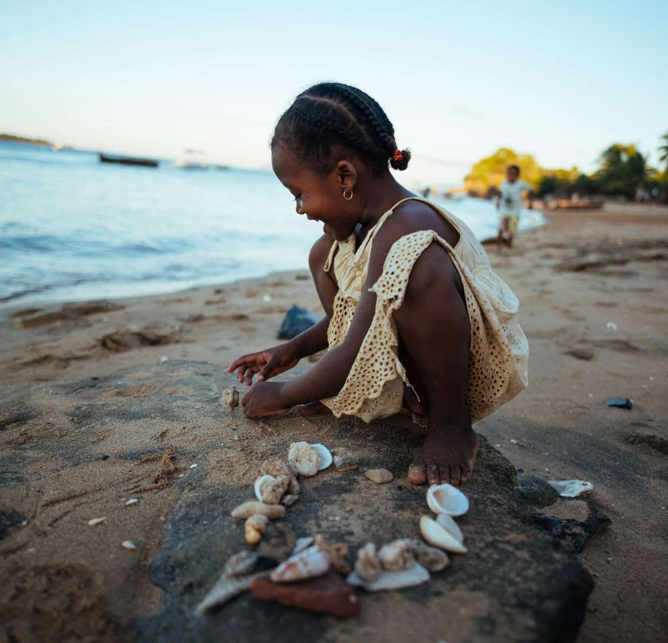 girl on the shore collecting seashells