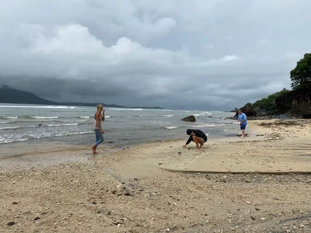 Volunteers completing beach cleanup as part of conservation efforts during wet season challenges.